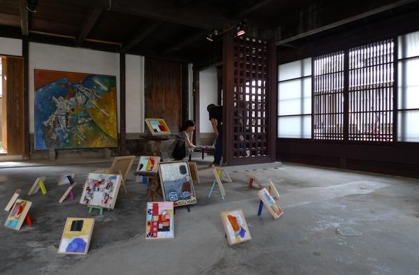 室内に置かれた大きさがばらばらのカラフルな額に入った絵画の写真